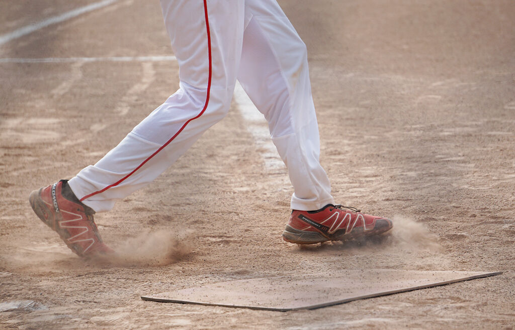 A batter pivots in the dust